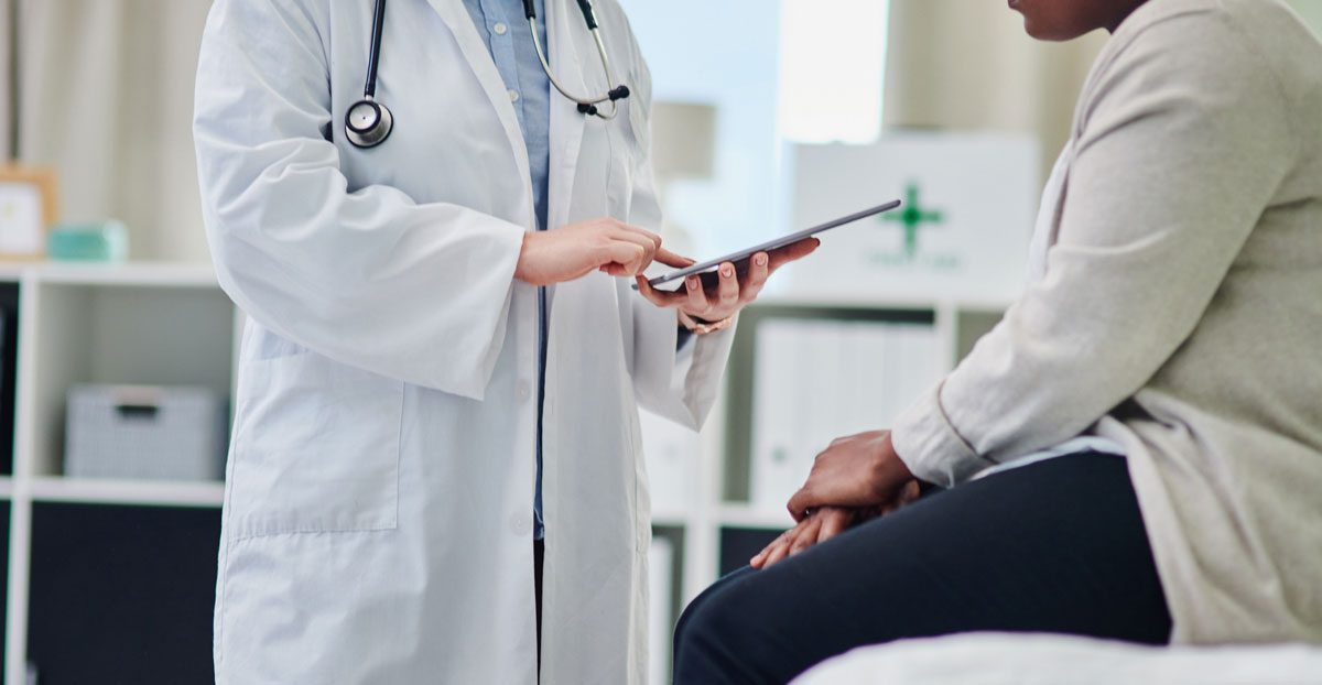 Doctor-consulting-patient-with-tablet Doctor-consulting-patient-with-tablet