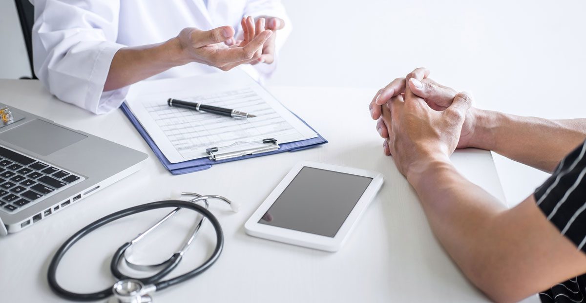 Doctor-consulting-with-patient-at-medical-office Doctor-consulting-with-patient-at-medical-office