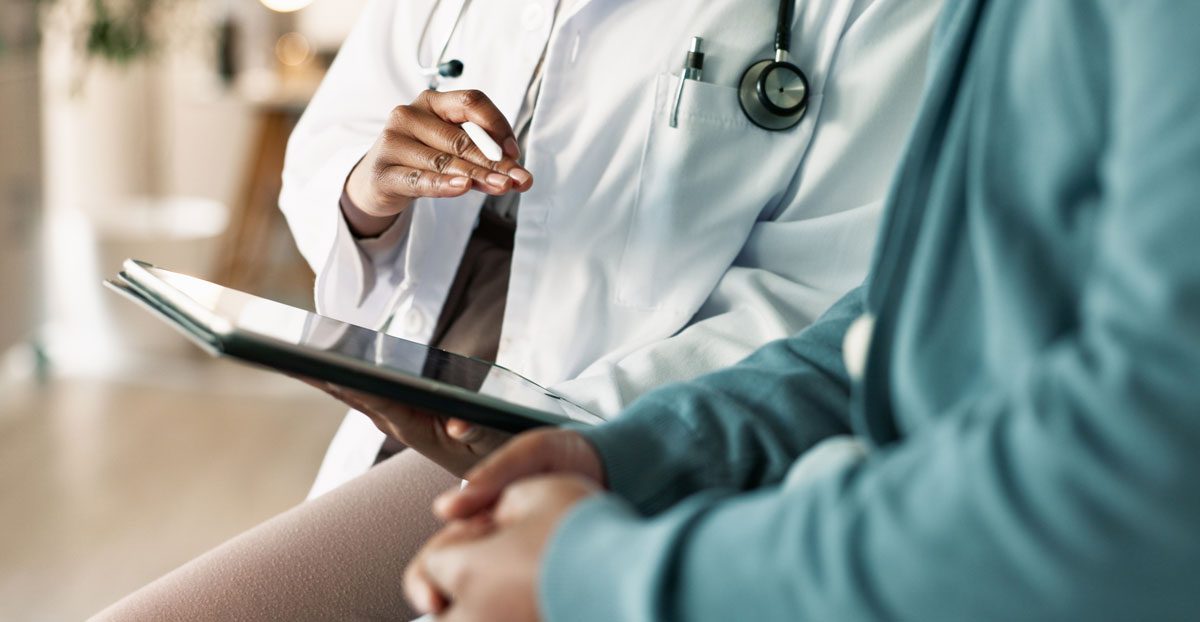 Doctor-discussing-treatment-with-patient-using-tablet Doctor-discussing-treatment-with-patient-using-tablet