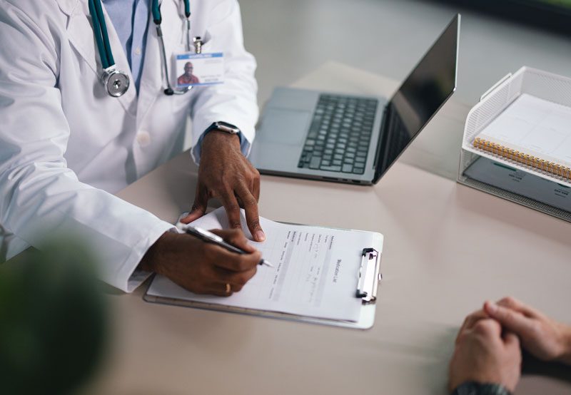 Doctor-reviewing-paperwork-with-patient Doctor-reviewing-paperwork-with-patient