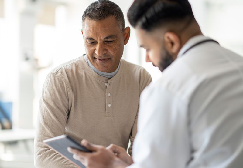Doctor-showing-tablet-to-patient Doctor-showing-tablet-to-patient