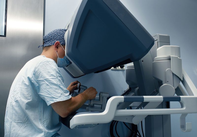 Surgeon-using-robotic-surgery-console Surgeon-using-robotic-surgery-console